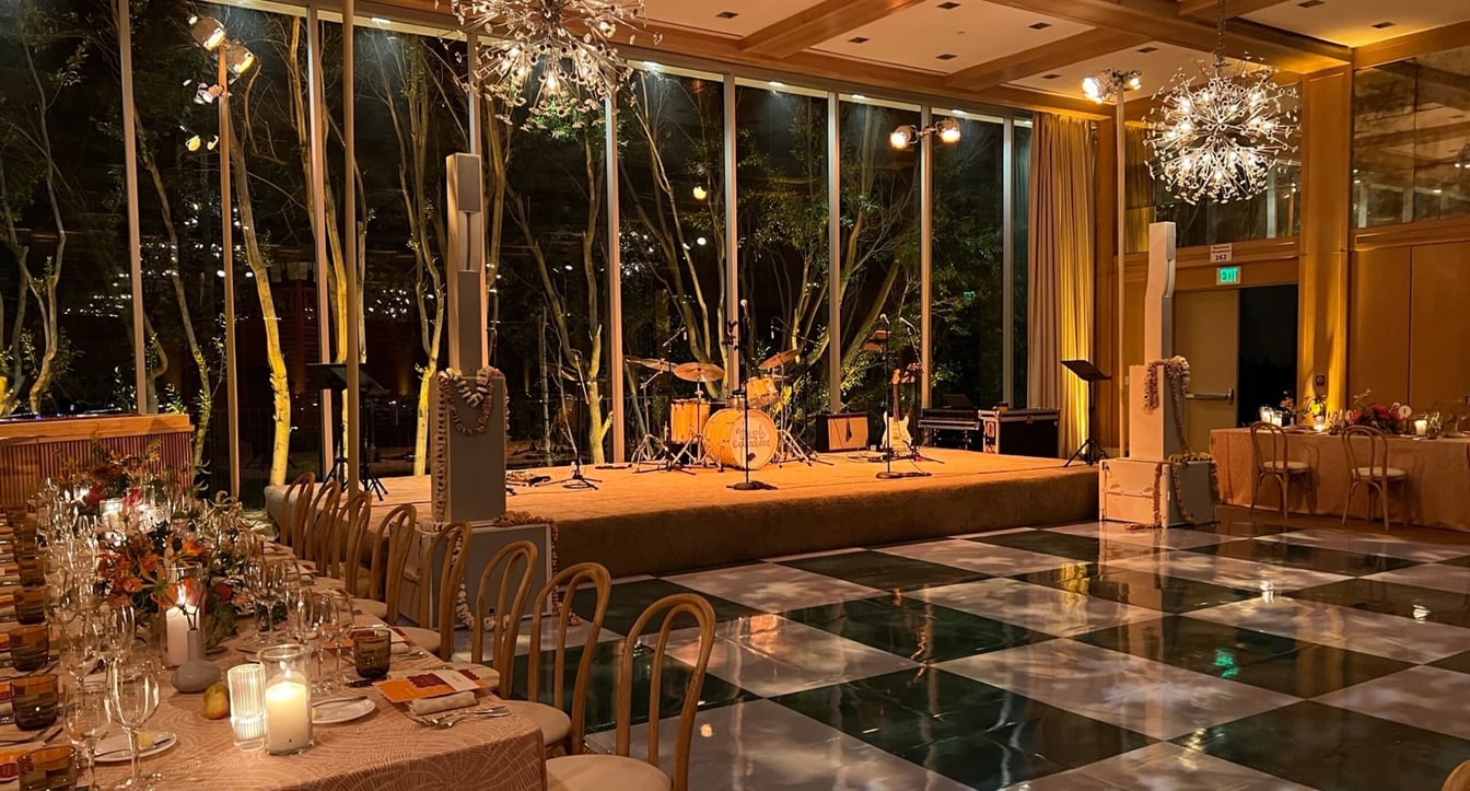 a large room with a stage and a long table set for dinner