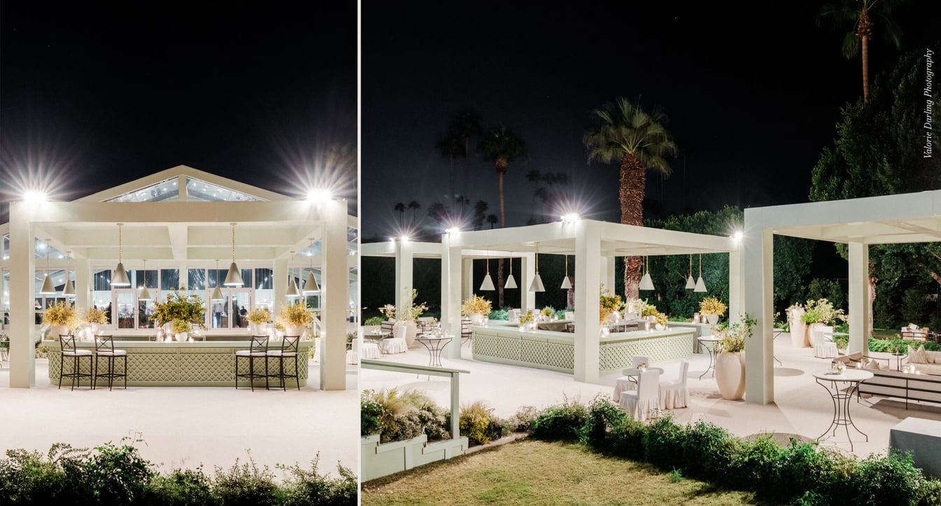 A nighttime view of an outdoor structure with white walls and roof, surrounded by palm trees and outdoor seating.