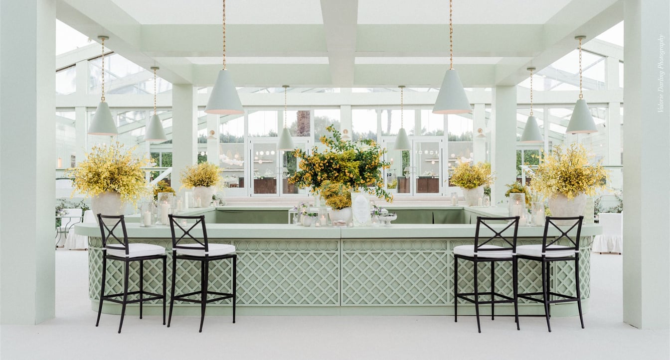 a bright and airy bar with a long counter, stools, and large windows