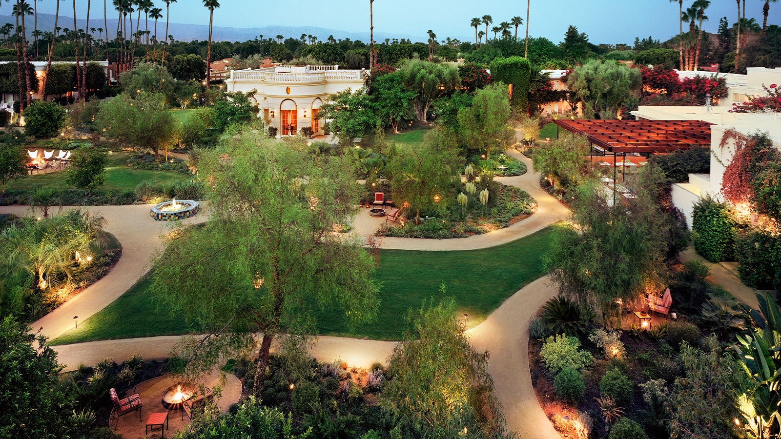 Aerial view of a landscaped outdoor area with pathways, seating areas, and a fire pit.