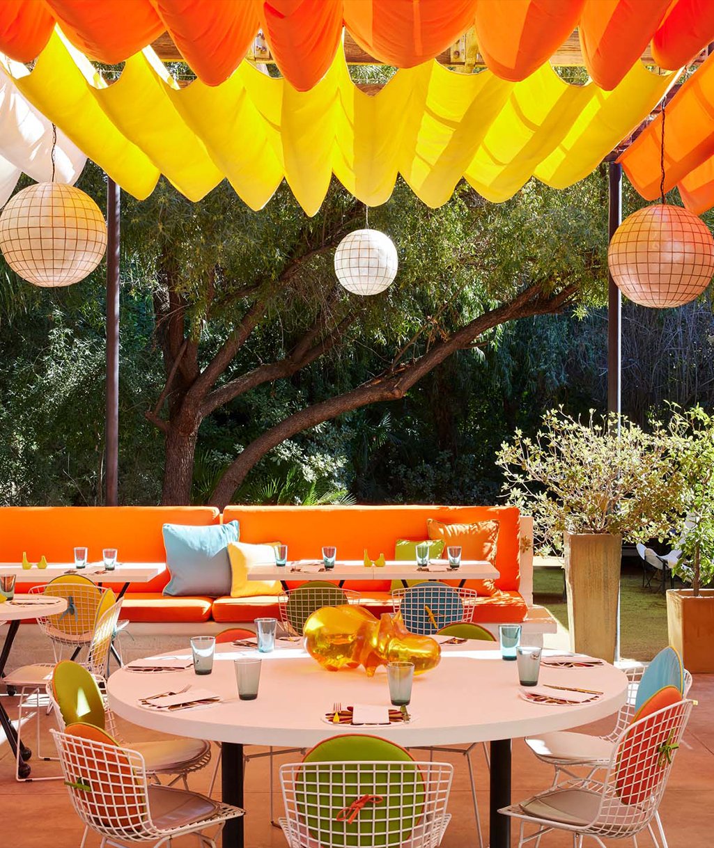 A vibrant outdoor dining area with colorful lanterns and modern furniture.