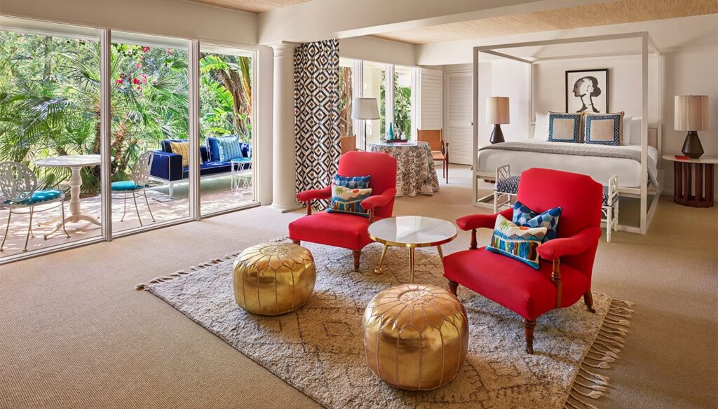 A spacious suite with a seating area, bed, and garden view