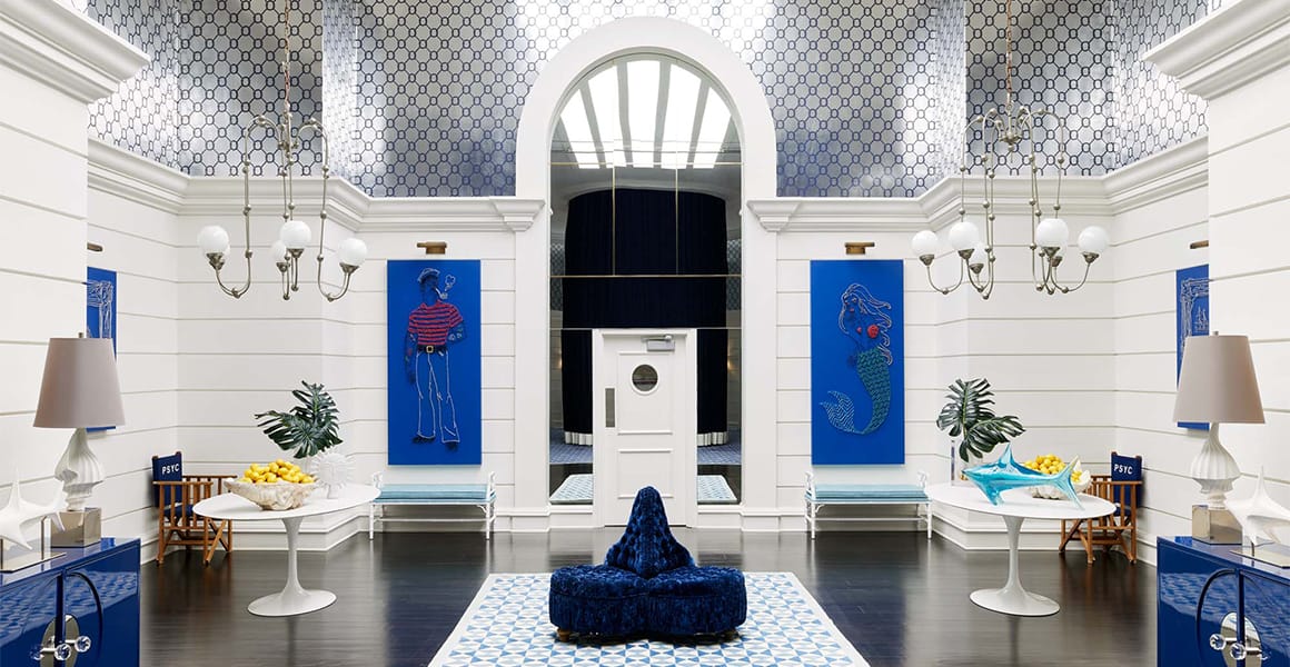 A spacious lobby with a high ceiling, chandeliers, and a blue and white color scheme.