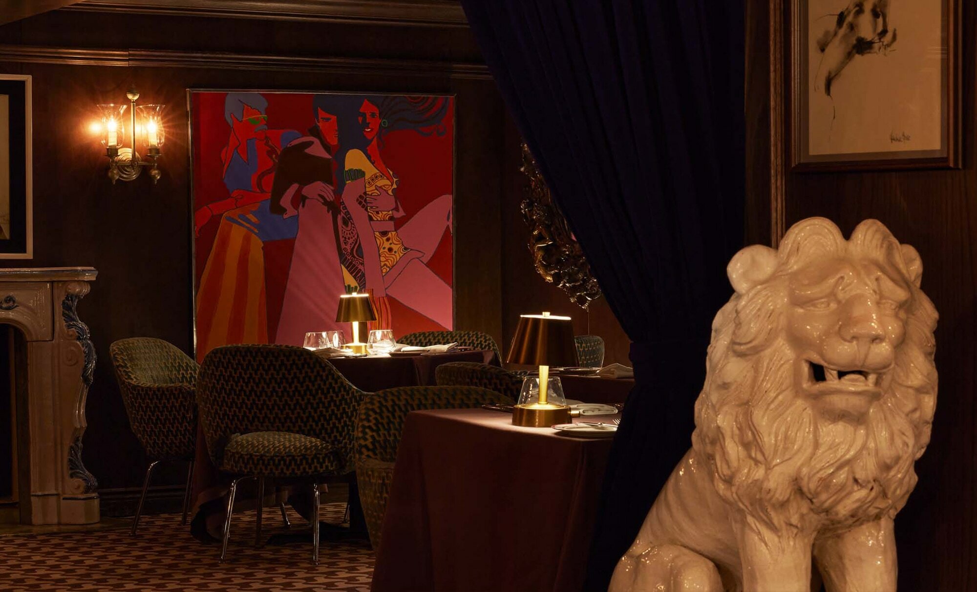 a dimly lit dining room with a large statue of a lion, a fireplace, and a colorful abstract artwork on the wall