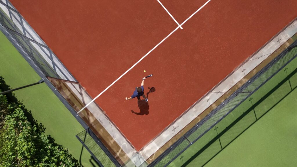 An aerial view of a tennis court with a player in action.