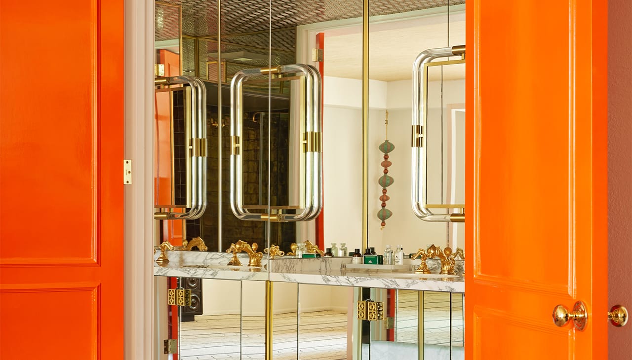 bathroom with orange door and granite sink