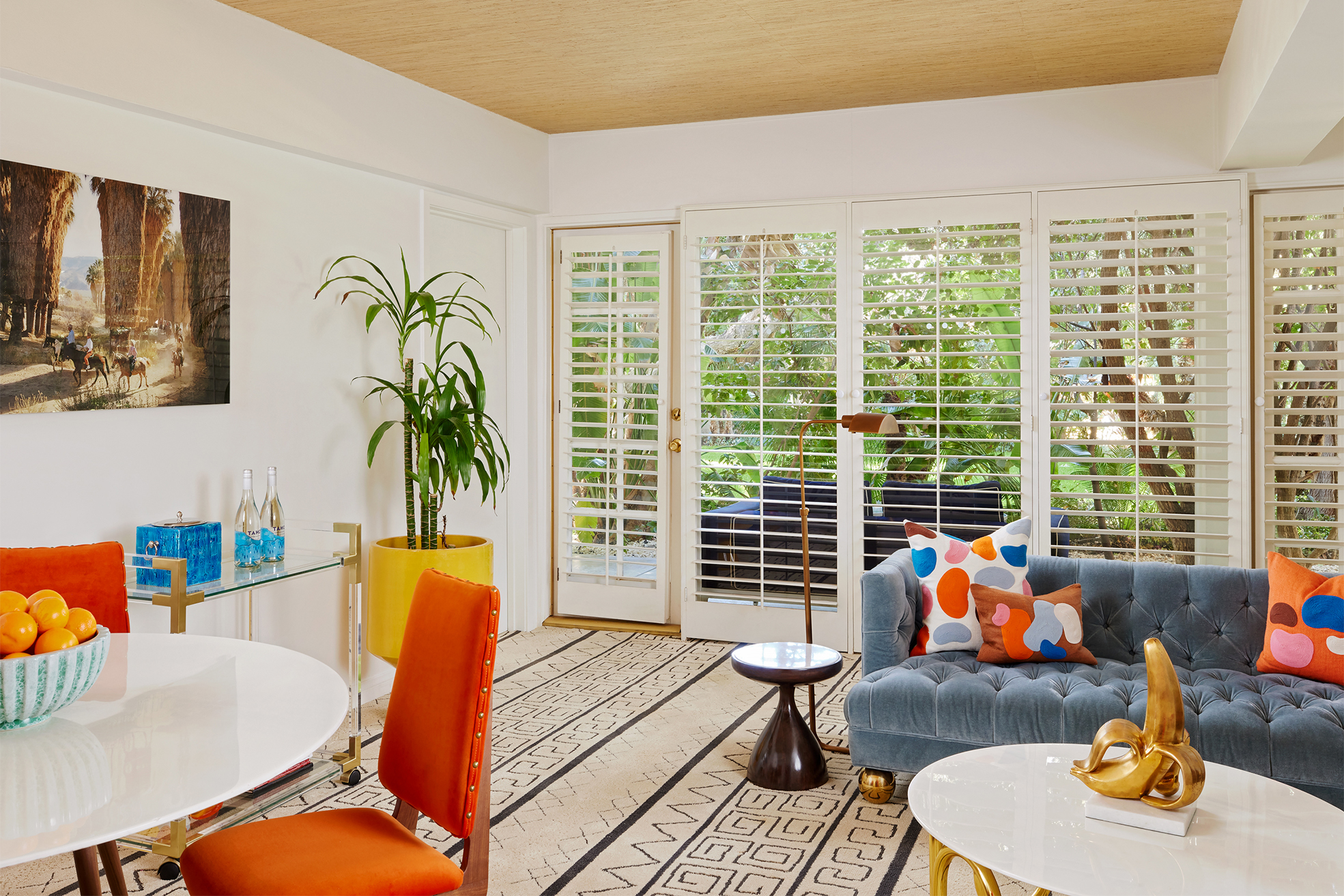 indoor view of hotel suite containing couch, coffee table, dining tables, and chairs